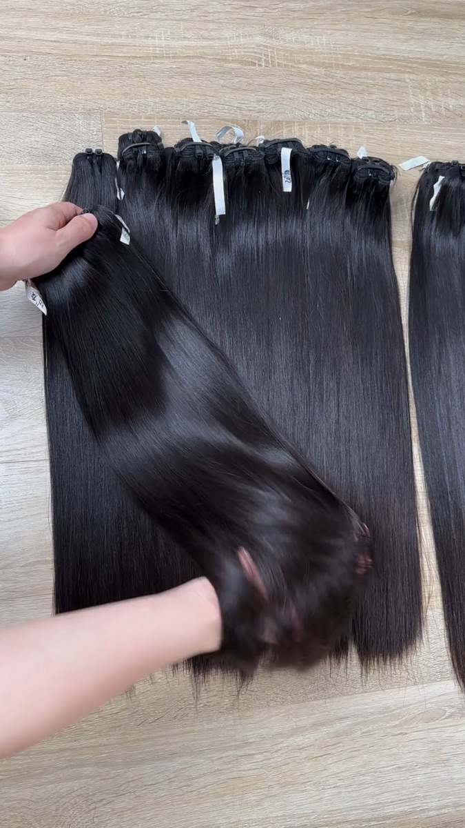Straight black human hair bundles being inspected